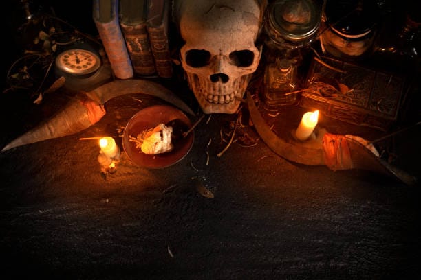 Mystical objects, skull, candles, old books, knives and materials for magic rituals.