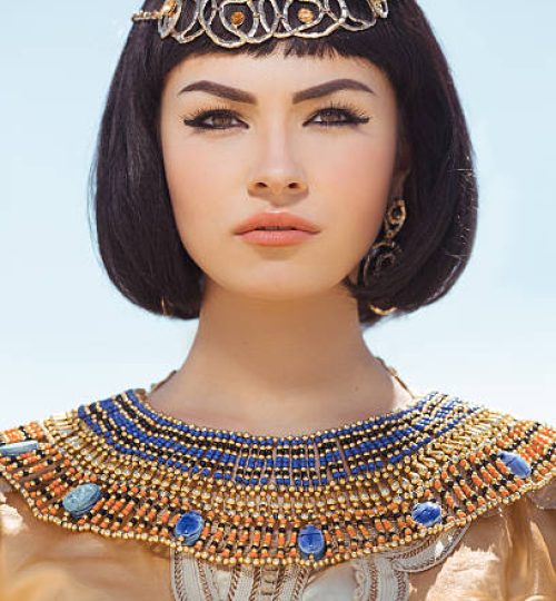 Portrait of young woman with luxury makeup. Beautiful girl with stylish haircut agaist desert background, young lady wearing fashionable golden necklace and dress. Beauty salon consept